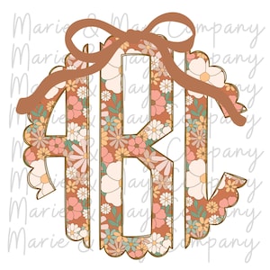 Op de afbeelding: Een bloemenmonogramontwerp met de letters ABJ in een bruine cirkel met geschulpte rand. De letters zijn gevuld met een patroon van roze, gele en witte bloemen. Een bruine strik zit bovenaan. De achtergrond is wit.