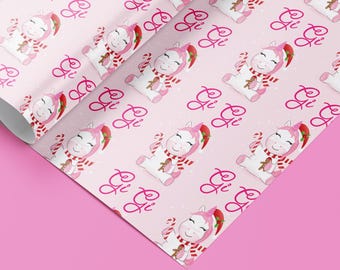 May include: Pink wrapping paper with a repeating pattern of a unicorn wearing a Santa hat and holding a candy cane. The unicorn is surrounded by white snowflakes and the text "Gi Gi" is repeated throughout the pattern.