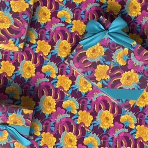 May include: Gift boxes wrapped in patterned paper featuring yellow flowers, purple snakes, and teal accents on a dark purple background. One box is tied with a teal satin bow.