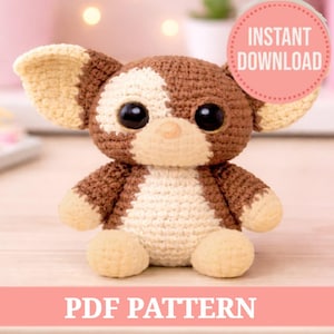 Puede incluir: Un peluche de ganchillo en marrón, crema y beige, con grandes ojos negros y una nariz beige redonda. El juguete tiene orejas grandes y está sentado erguido. La imagen incluye un círculo rosa con las palabras "INSTANT DOWNLOAD" y el texto "PDF PATTERN".