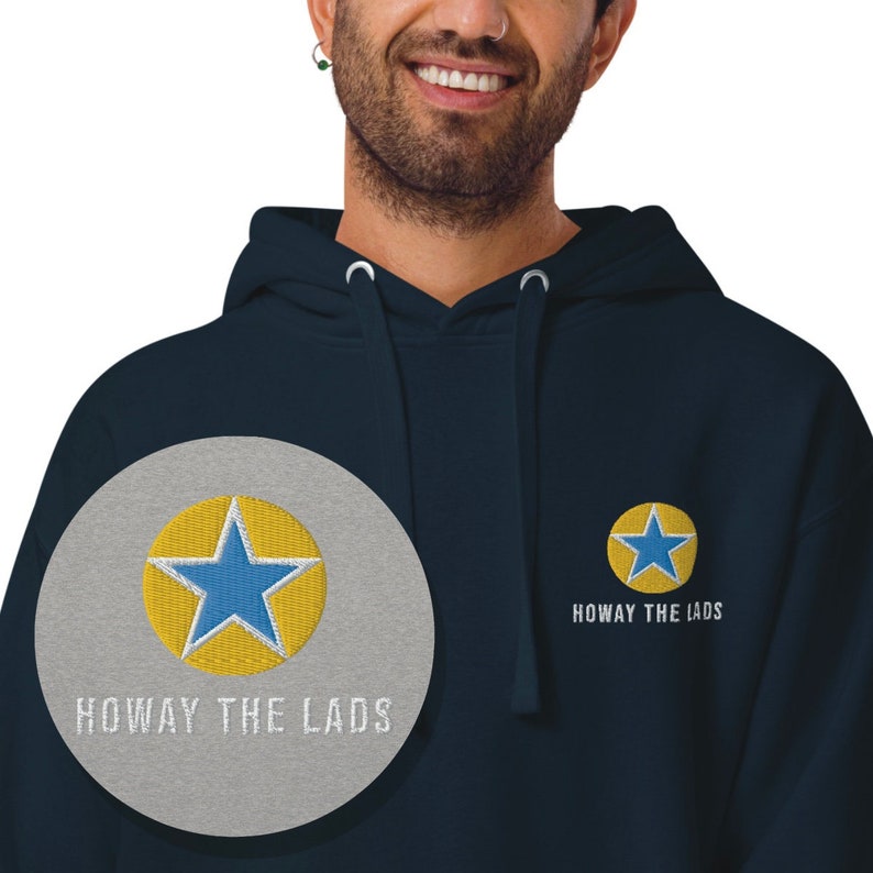 K&ouml;nnte beinhalten: Marineblauer Hoodie mit einem gelben Stern und dem gestickten Text "Howay the Lads" auf der Vorderseite.