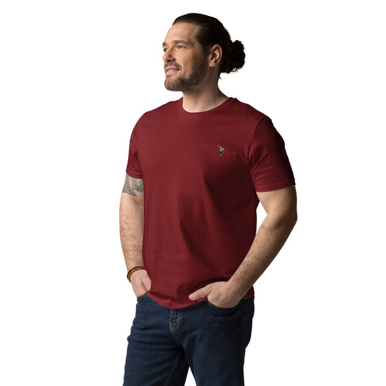 May include: A maroon short-sleeved t-shirt with a small embroidered design on the left chest.