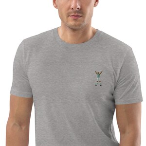 May include: A heather gray t-shirt with an embroidered image of a soccer player celebrating a goal.