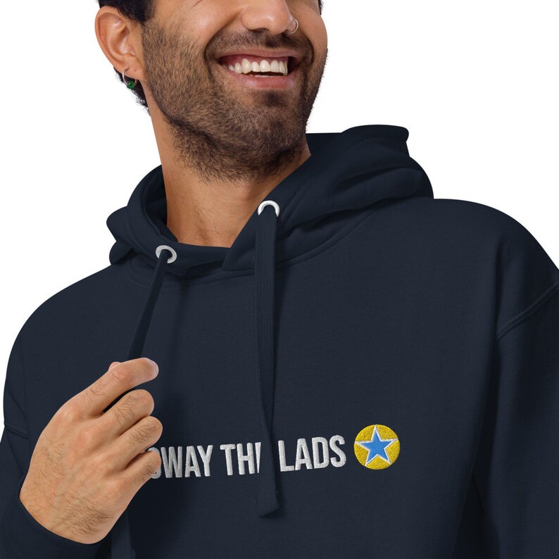 Puede incluir: Sudadera con capucha azul marino con una estrella blanca y el texto "AWAY THI LADS" en blanco.