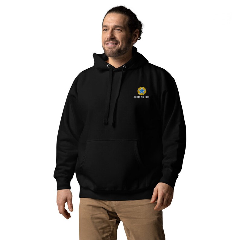 K&ouml;nnte beinhalten: Schwarzer Kapuzenpullover mit einem gelben Kreis und einem blauen Stern auf der linken Brust. Der Text "Know the Code" ist unter dem Grafikdruck.