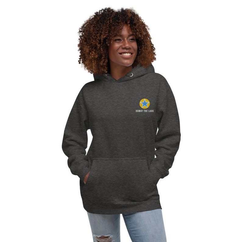 K&ouml;nnte beinhalten: Ein dunkelgrauer Hoodie mit einem gelben Kreis und einem blauen Stern in der Mitte. Der Text "Noway The LACS" steht unter dem Kreis.