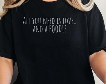 May include: A black t-shirt with the text "All you need is love... and a poodle." printed in white.