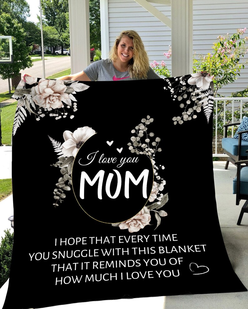 Puede incluir: Manta de microfibra con estampado floral en blanco y negro con el texto "I love you MOM" y "I hope that every time you snuggle with this blanket that it reminds you of how much I love you" en blanco.