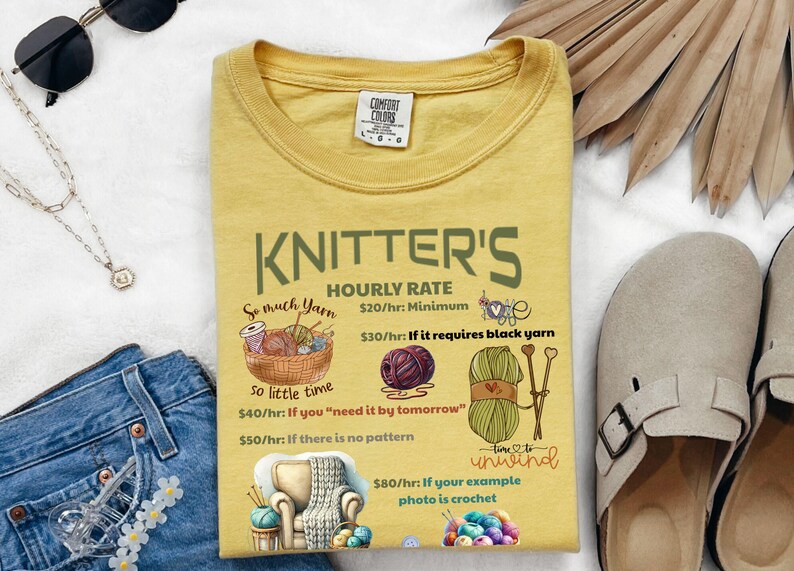 May include: A yellow t-shirt with a humorous graphic about knitter's hourly rates. The graphic features yarn, needles, and a chair with a blanket. The text reads "KNITTER'S HOURLY RATE So much yarn So little time $20/hr: Minimum $30/hr: If it requires black yarn $40/hr: If you "need it by tomorrow" $50/hr: If there is no pattern $80/hr: If your example photo is crochet"