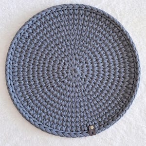 Könnte beinhalten: Eine weiße Keramik-Tasse mit schwarzem Henkel und dem Text "But First, Coffee" in fetter, schwarzer Schrift. Die Tasse steht vor einem verschwommenen Hintergrund. Die Tasse ist etwa 10 cm hoch.