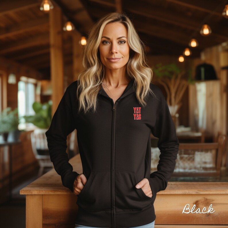 May include: A black zip-up hoodie with a red "Y'all Yas" graphic on the front.