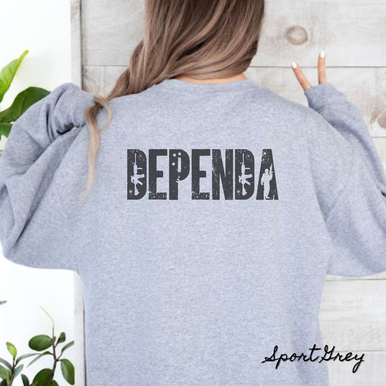 May include: A gray sweatshirt with the word "DEPENDA" printed on the back in a distressed font. The word is flanked by two stylized rifles and a silhouette of a soldier.