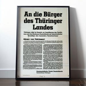 Op de afbeelding: Een zwart-witte poster met de tekst "An die Bürger des Thüringer Landes" in vetgedrukte, zwarte letters. De poster is een politieke boodschap van de Communistische Partij van Duitsland, die de burgers van Thüringen oproept om verantwoordelijkheid te nemen voor de strijd tegen het fascisme en de wederopbouw van Duitsland.