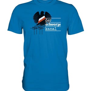 Op de afbeelding: Een felblauw t-shirt met een zwart silhouet van een adelaar met een rood-witte vlag op zijn borst. De tekst "der schwarze kanal" is onder de adelaar gedrukt.