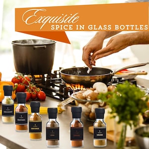 May include: A selection of spice jars with black lids, labelled with various spices. The image includes the text "Exquisite Spice in Glass Bottles". A person is cooking in the background, adding spices to a pan. Tomatoes and mushrooms are also visible.