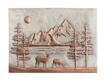 May include: A copper wall art piece depicting a mountain scene with two deer in the foreground. The mountains are in the background with a lake in front of them. The scene is surrounded by trees on either side.