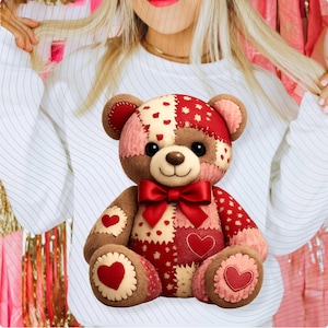 Könnte beinhalten: Ein Teddybär aus Patchwork mit roter Schleife und Herzakzenten. Der Bär hat eine Mischung aus roten, rosa und cremefarbenen Flicken mit herzförmigen Details auf den Pfoten und dem Kopf. Er hat eine braune Nase und schwarze Augen.