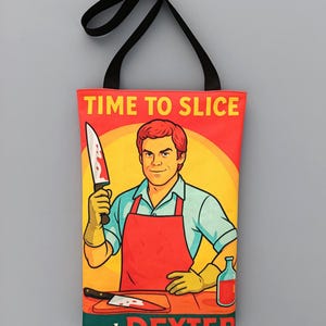 Puede incluir: Un bolso tote rojo con asa negra. Presenta una ilustración de dibujos animados de un hombre con delantal rojo sosteniendo un cuchillo ensangrentado, con el texto "TIME TO SLICE and DEXTER" arriba y abajo.