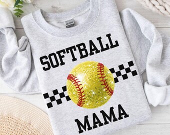 May include: Gray sweatshirt with the text "SOFTBALL MAMA" in black. A sparkly yellow softball with red stitching is centered on the shirt. A black and white checkered pattern is above and below the softball.