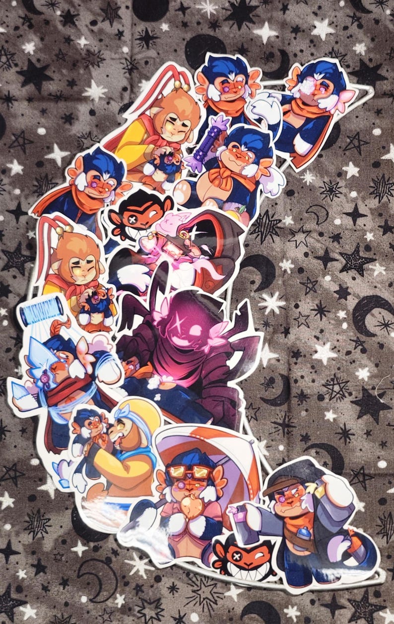 Puede incluir: Una colecci&oacute;n de pegatinas de dibujos animados coloridos con personajes parecidos a monos en varias poses. Las pegatinas tienen un borde blanco y est&aacute;n dispuestas sobre un fondo de tela gris con patrones de estrellas y lunas. Los personajes visten trajes en tonos azules, naranjas y amarillos.