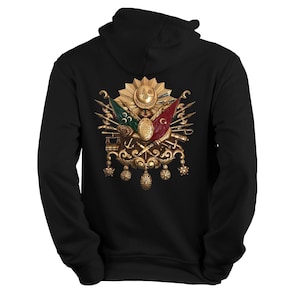 Op de afbeelding: Zwarte hoodie met een geborduurd Ottomaans wapenschild in goud met een halve maan, een ster en vlaggen.