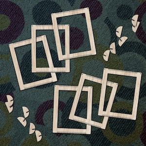 Puede incluir: Un conjunto de ocho telares de madera de diferentes tamaños, dispuestos en forma escalonada sobre una superficie texturizada verde y marrón. Los telares están hechos de madera natural y tienen un diseño simple y rústico.