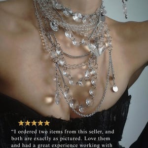 dramatic multi-strand clear quartz necklace on a model with large crystal heart pendants and stainless steel chains, featuring a 5-star customer review overlay confirming the jewelry is exactly as pictured and highlighting a great seller experience