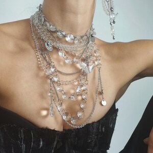 Layered crystal necklace and earrings set with multi-strand quartz beads and chandelier style pendants.
​