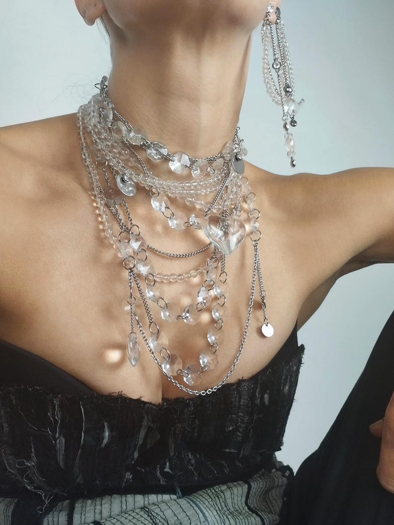 Layered crystal necklace and earrings set with multi-strand quartz beads and chandelier style pendants.
​