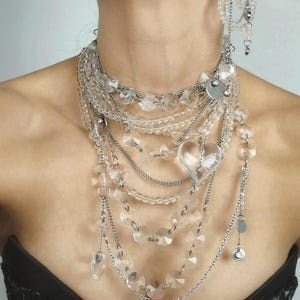 Clear quartz beads and crystal heart detail on multi-row stainless steel jewelry hardware.
​