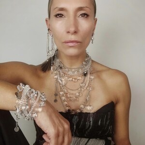 ​Clear quartz statement jewelry set full look on a model featuring all layered pieces and crystal heart accents.