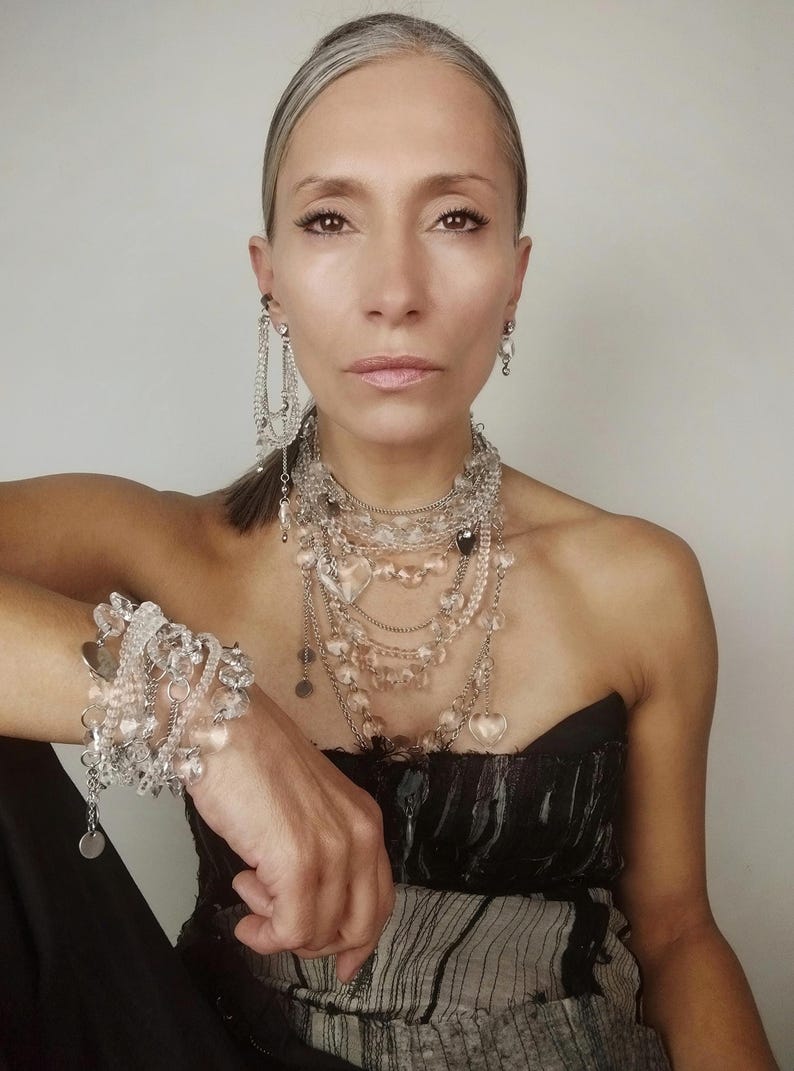 ​Clear quartz statement jewelry set full look on a model featuring all layered pieces and crystal heart accents.