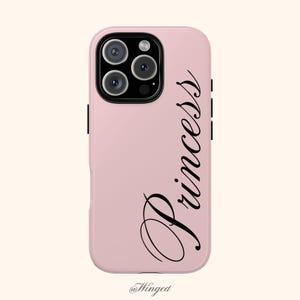 May include: A light pink phone case with the word "Princess" in black script. The case has a camera module with three lenses and a flash. The bottom of the case has the text "@Winged".