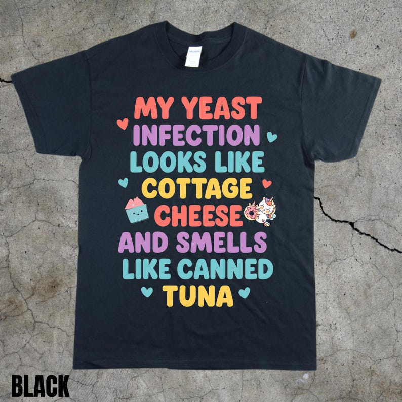 Puede incluir: Camiseta negra con el texto colorido "MY YEAST INFECTION LOOKS LIKE COTTAGE CHEESE AND SMELLS LIKE CANNED TUNA". La camiseta tiene cuello redondo y mangas cortas. La palabra "BLACK" est&aacute; impresa en la parte inferior.