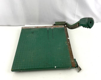 May include: Green paper trimmer with a metal blade and a handle. The cutting surface is green and has a grid pattern.