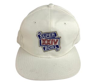 May include: White baseball cap with a flat brim. The cap features a patch with the text "SUPER XXIV BOWL" in blue and red lettering. The cap is made of a sturdy fabric and has a classic, structured design.