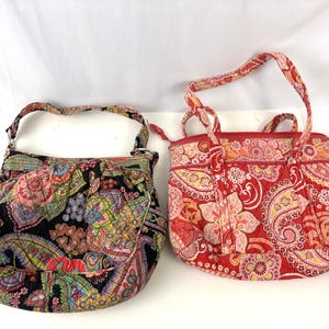 Puede incluir: Dos bolsos de tela con coloridos estampados de cachemira. Uno es negro con solapa, el otro es rojo con asa superior. Ambos bolsos tienen una textura acolchada y son adecuados para transportar objetos.