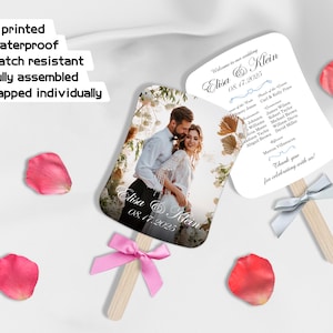 Może przedstawiać: Biały wachlarz ślubny z fotografią pary na przodzie i programem ślubnym na odwrocie. Wachlarz jest ozdobiony niebieską wstążką i różową kokardką.