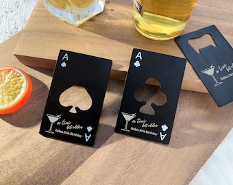 Könnte beinhalten: Zwei schwarze kartenförmige Flaschenöffner mit einem Pik- und einem Kleeblatt-Design. Jeder Öffner hat einen Ausschnitt für einen Flaschenverschluss und den Text "a tiny bit older Bella's 30th Birthday".