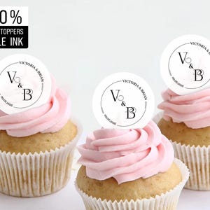 May include: Three pink cupcakes with white frosting and edible round toppers that say "Victoria & Brian" with the initials "V & B" and the date "03.08.2020".