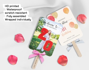 May include: Two personalized birthday fans with wooden handles and pink bows. One fan features a photo and the number 20, the other has balloons and text that reads "Birthday Willow". Scattered around are pink rose petals.