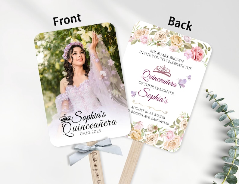 May include: A double-sided fan with a photograph of a young woman in a formal gown on the front. The back features floral designs and text that reads "Quincea&ntilde;era" and event details. A light blue ribbon is attached to the wooden handle.