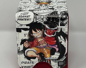 May include: A red and black deck box featuring a comic book style illustration of a character from the anime One Piece. The character is wearing a red shirt, yellow shorts, and a black hat. The text on the box reads "...YOU FIGHT AGAINST PIRATES!!" and "PIRATE KING!!"