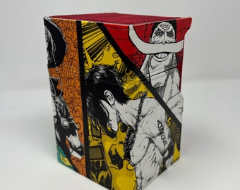 May include: A colorful card deck box featuring a collage of characters from the anime One Piece. The box is made of sturdy cardboard and has a unique design with a red, yellow, and black color scheme.
