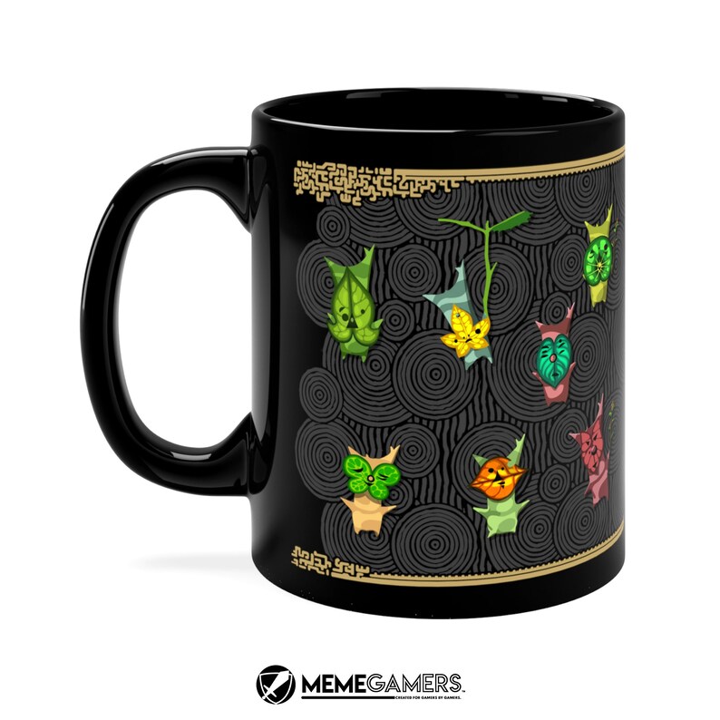 Puede incluir: Taza de cer&aacute;mica negra con un dise&ntilde;o de personajes coloridos sobre un fondo blanco y negro. Los personajes son estilizados y tienen una apariencia de dibujos animados. La taza tiene un borde dorado y un dise&ntilde;o dorado en la parte inferior.