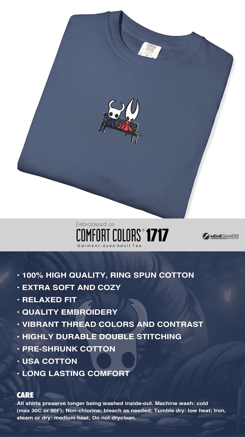 Pode incluir: Uma t-shirt azul ard&oacute;sia com um pequeno bordado centrado de duas personagens estilizadas sentadas num banco. Uma personagem &eacute; branca com detalhes pretos e a outra &eacute; vermelha com detalhes pretos. A t-shirt tem gola redonda e uma etiqueta.