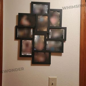 May include: A black picture frame collage with 10 individual frames, each containing a blurred image of a person. The frames are arranged in a heart shape on a white wall.