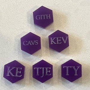 May include: Six purple hexagonal tiles with white lettering. The tiles spell out the words "GITH", "CAVS", "KEV", "KE", "TJE", and "TY".