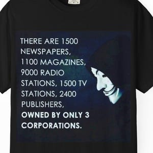 May include: Black t-shirt with the text "THERE ARE 1500 NEWSPAPERS, 1100 MAGAZINES, 9000 RADIO STATIONS, 1500 TV STATIONS, 2400 PUBLISHERS, OWNED BY ONLY 3 CORPORATIONS." and a graphic of a smiling face.
