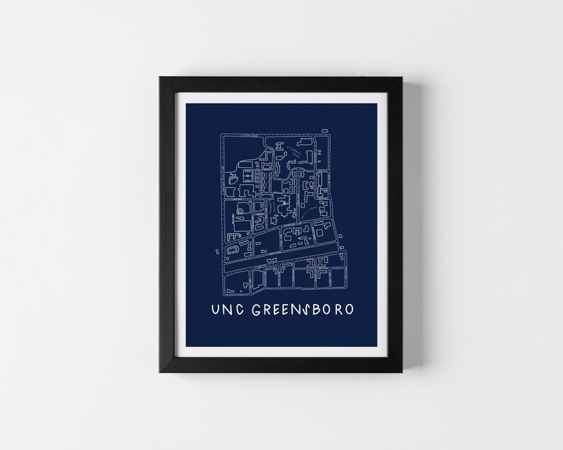 Op de afbeelding: Ingelijste print met een gedetailleerde witte lijntekening van een kaart op een marineblauwe achtergrond. De tekst "UNC GREENSBORO" staat onderaan. De print zit in een zwart frame, ideaal voor wanddecoratie, in cm.